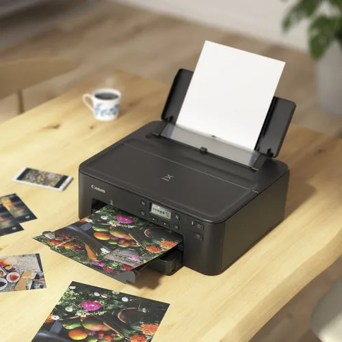 Canon PIXMA TS707A on a desk printing photographs